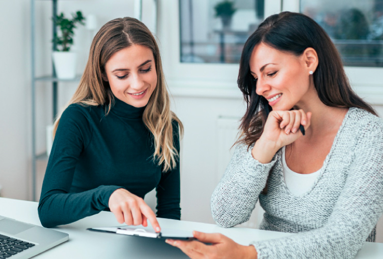 Zwei Frauen besprechen Inhalte am Tablet im Büro als Symbol für berufliches Einzelcoaching bei TASys – TASys