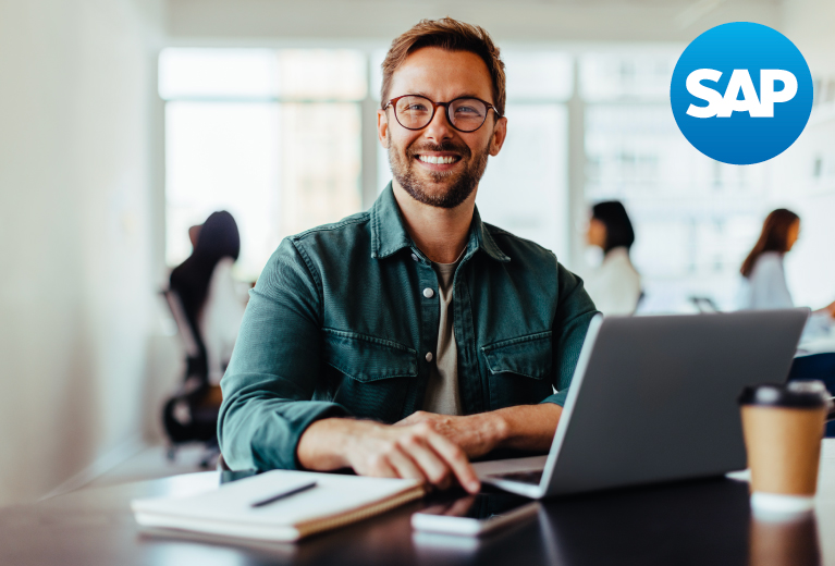 Lächelnder Mann arbeitet mit Laptop im modernen Büro vor SAP-Logo während einer Schulung – TASys