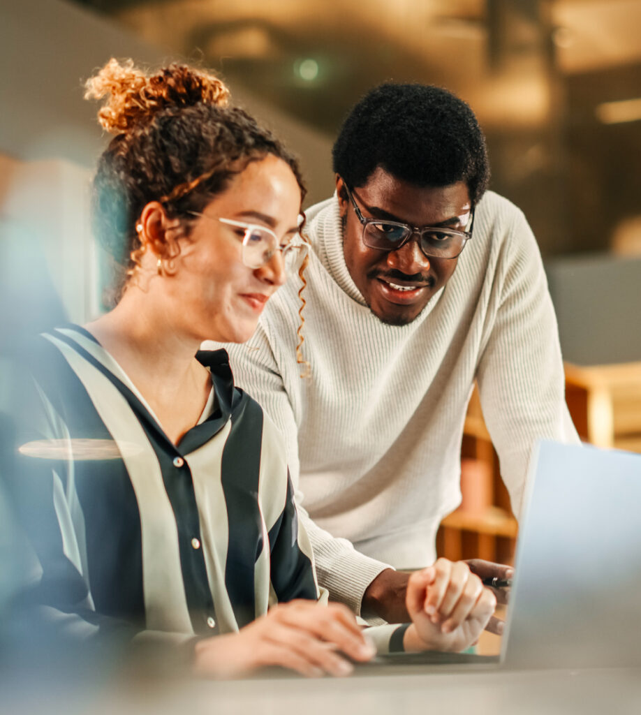 Zwei Personen arbeiten gemeinsam am Laptop als Symbol für Multimedia Kursübersicht und digitale Weiterbildung bei TASys – TASys