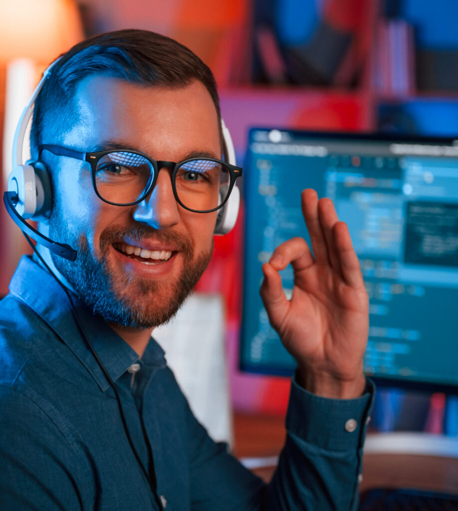 Mann mit Headset arbeitet am Computer mit Code Anzeige als Symbol für Informationstechnik Kursübersicht bei TASys – TASys