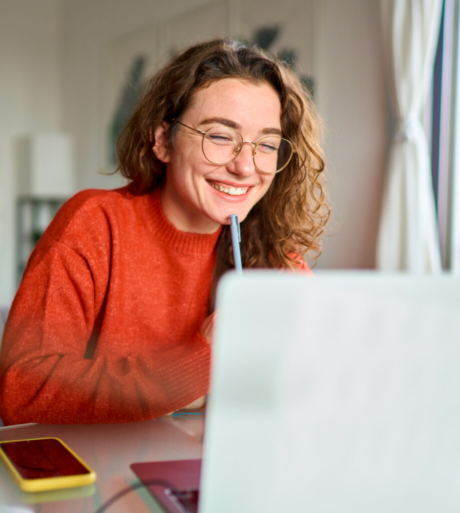 Lächelnde Frau arbeitet am Laptop als Symbol für Microsoft Kursübersicht und Weiterbildung bei TASys – TASys