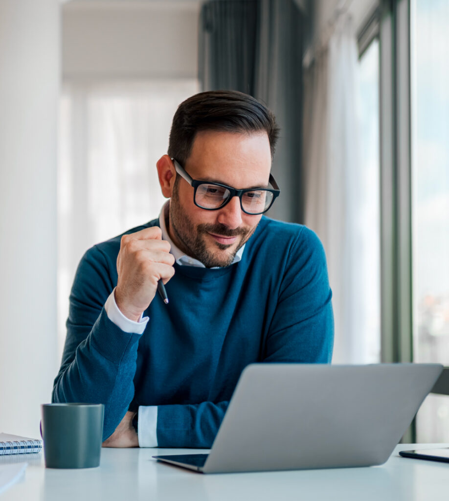 Mann arbeitet konzentriert am Laptop im Büro als Symbol für individuelle SAP Trainings Kursübersicht bei TASys – TASys